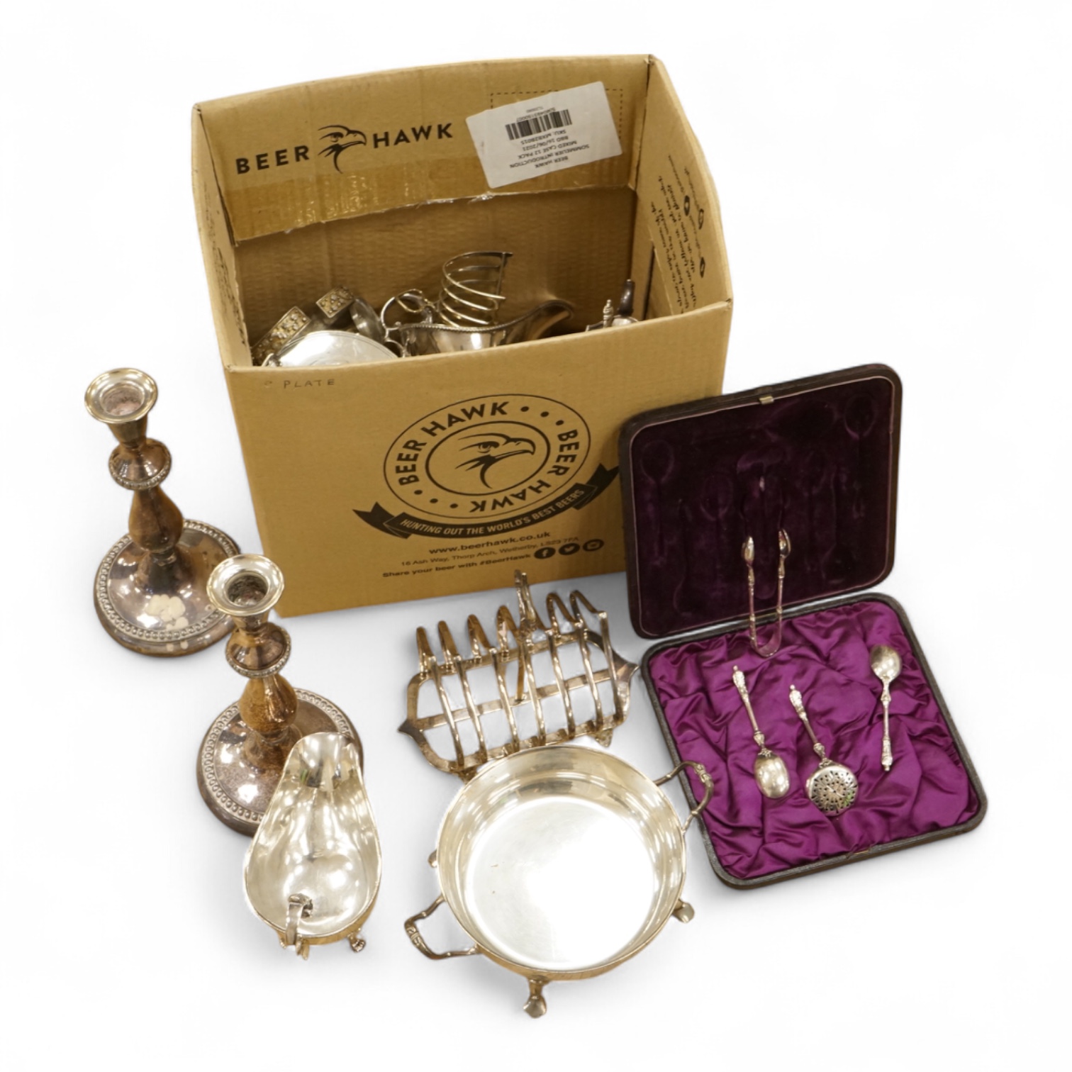 A quantity of assorted plated wares, including flatware, a tea caddy, a chatelaine, a toast rack, a sauceboat, a butter dish and a pair of candlesticks, etc.
